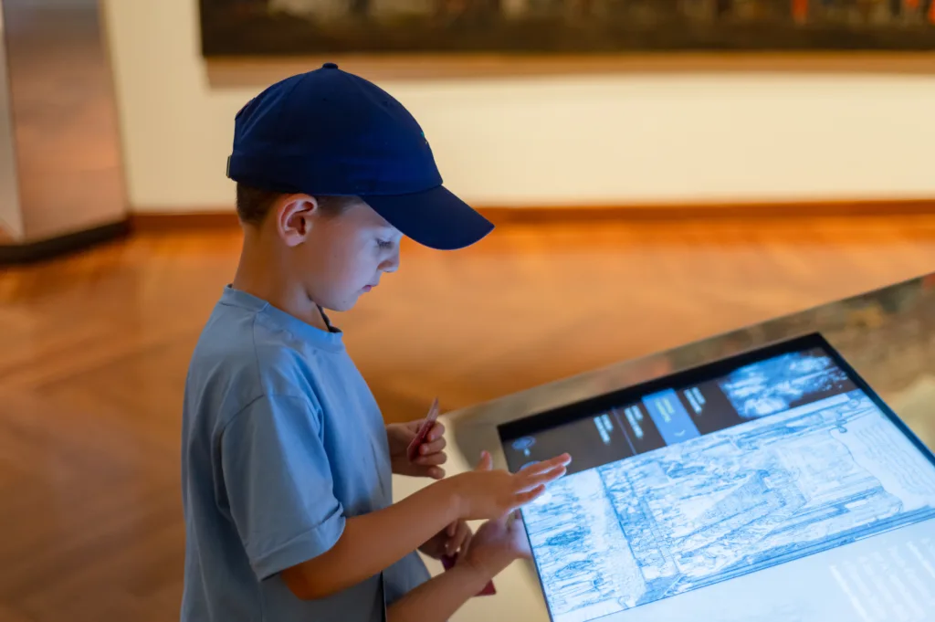 Child using an interactive map inside of a museum