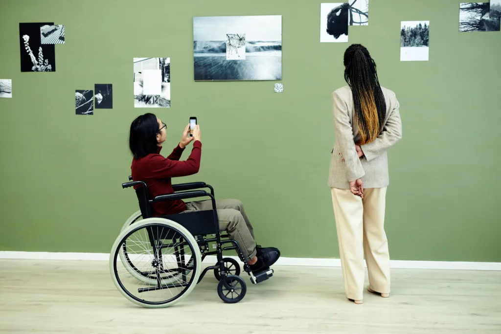 Person in a wheelchair taking photos on a museum